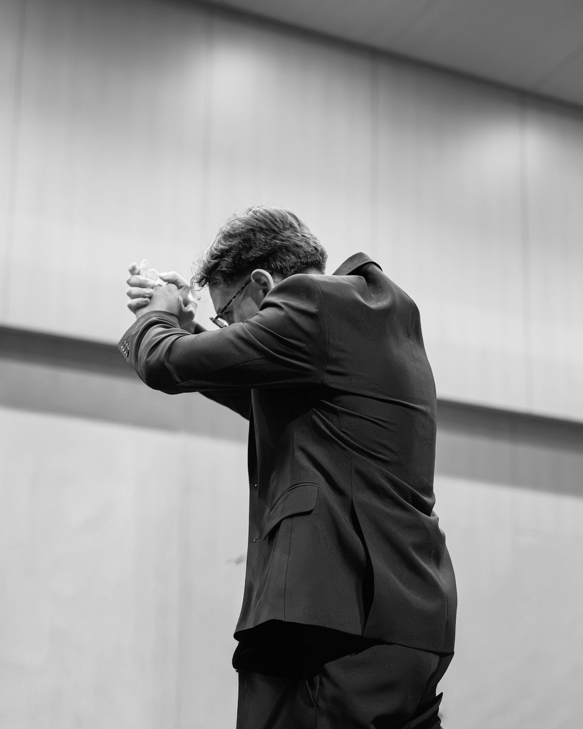 Guillermo López Calleja con las manos unidas ante la orquesta
